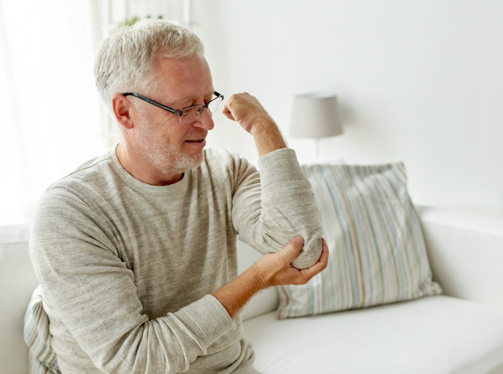 a old man having a elbow pain