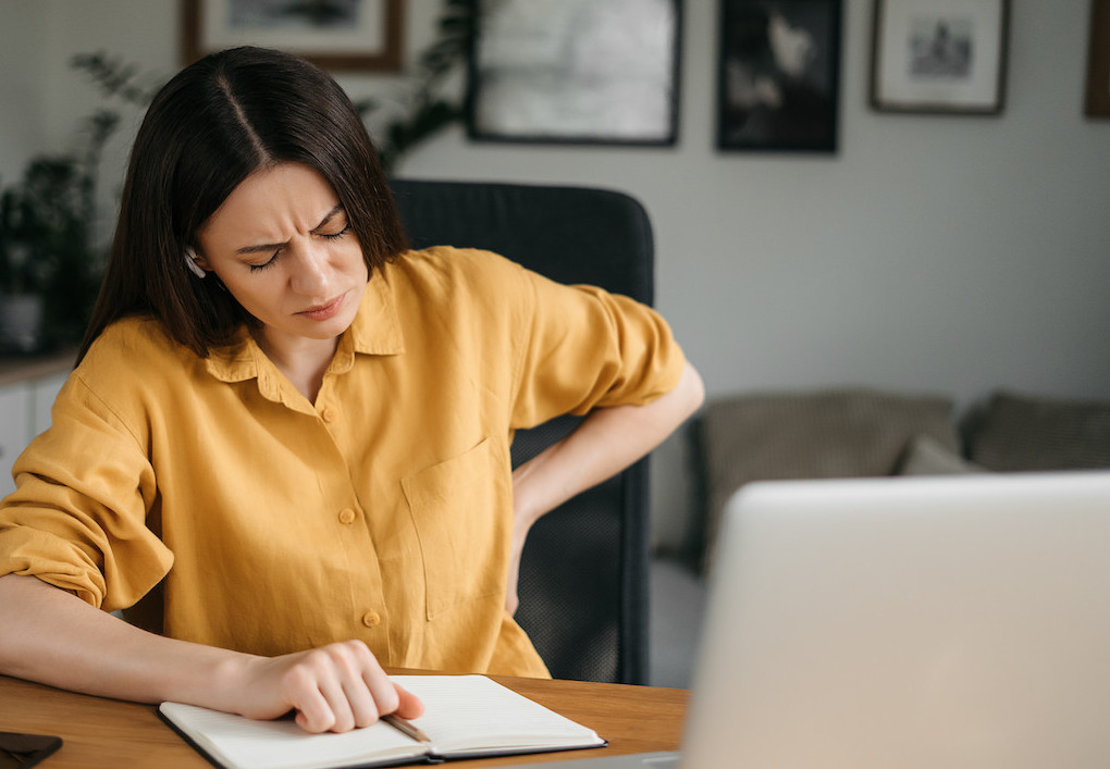 a woman having a back pain from a poor posture